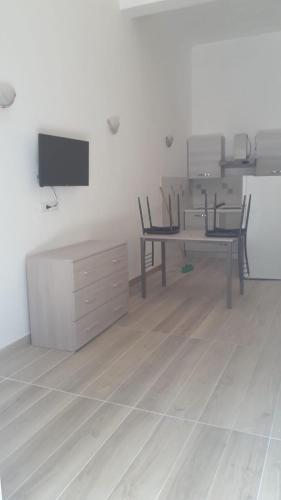 a room with a desk and chairs and a tv at SanMarco Holiday Home in Ascea