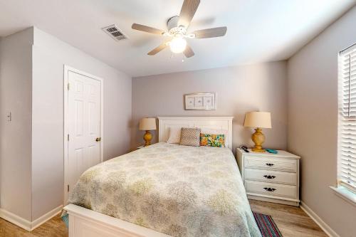 um quarto com uma cama e uma ventoinha de tecto em The Beach House em Gulf Shores