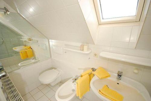 a white bathroom with a sink and a toilet at Ferienwohnung-Krause in Munkmarsch