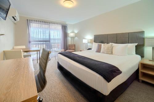 a hotel room with a large bed and a desk at Albany Motel & Apartments in Albany