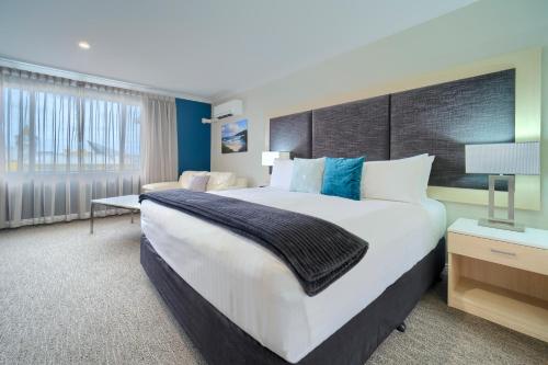 a large bedroom with a large bed and a window at Albany Motel & Apartments in Albany