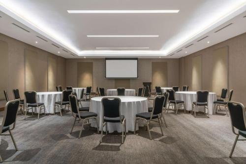 a conference room with tables and chairs and a screen at Radisson Blu Hotel & Residence Maputo in Maputo