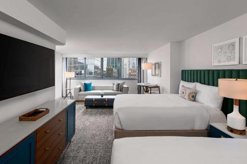 a hotel room with two beds and a flat screen tv at The Royal Sonesta Chicago Downtown in Chicago