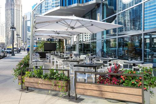 a restaurant with tables and umbrellas on a city street at The Royal Sonesta Chicago Downtown in Chicago