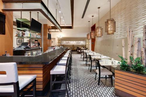 a restaurant with a long bar with white tables and chairs at The Royal Sonesta Chicago Downtown in Chicago