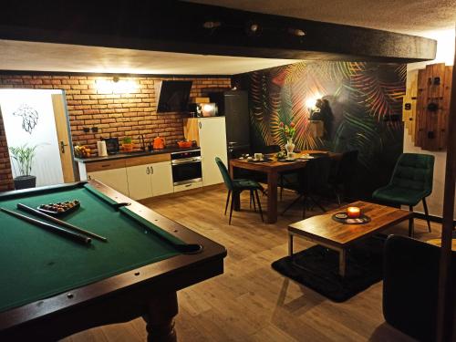 a living room with a pool table and a kitchen at Apartamencik za lasem in Krynica Zdrój