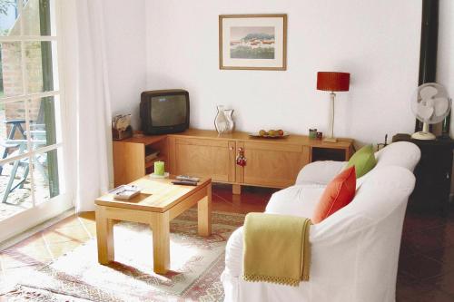 a living room with a white couch and a tv at Holiday Home bei Viana do Castelo Carreco - PON03016-F in Carreço