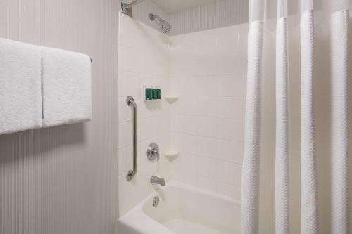a white bathroom with a tub and a shower at Sonesta Select Los Angeles LAX El Segundo in El Segundo