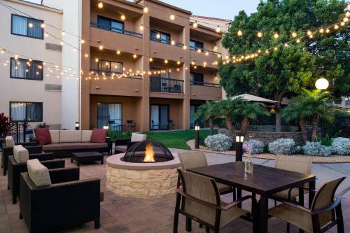 a hotel patio with tables and chairs and a fire pit at Sonesta Select Los Angeles LAX El Segundo in El Segundo