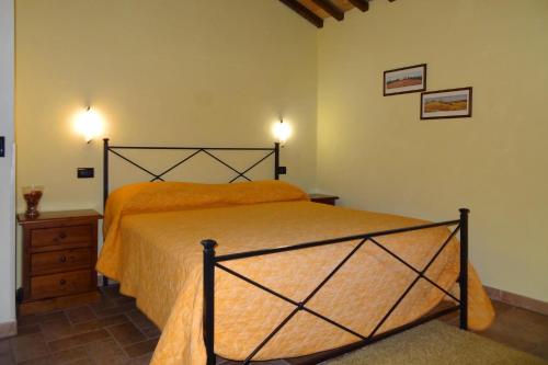 沃爾泰拉的住宿－Farmhouse stay Giulia Volterra，一间卧室配有一张带橙色床罩的床