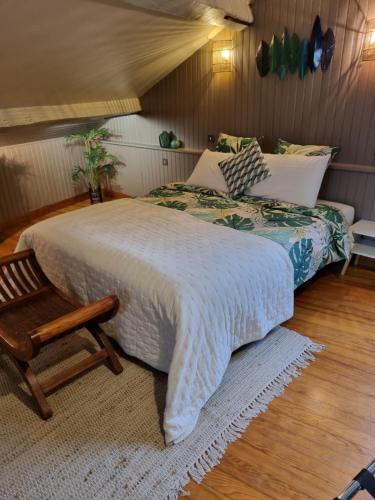 a bedroom with a large bed and a chair at Les Glycines de Monchy- Chambres d'hôtes in Monchy-Humières