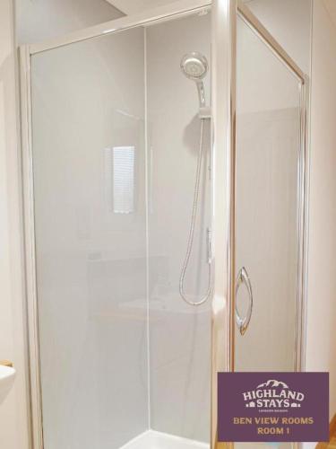 a shower with a shower head in a bathroom at Highland Stays - Ben View Room & Jacuzzi Bath in Fort William