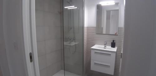 a white bathroom with a shower and a sink at los perlas in El Campello