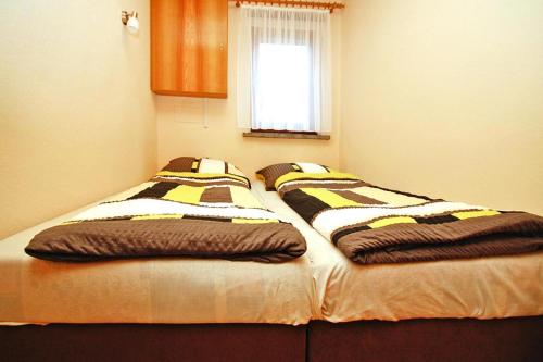 2 Einzelbetten in einem Zimmer mit Fenster in der Unterkunft Holiday home, Luebben in Lübben