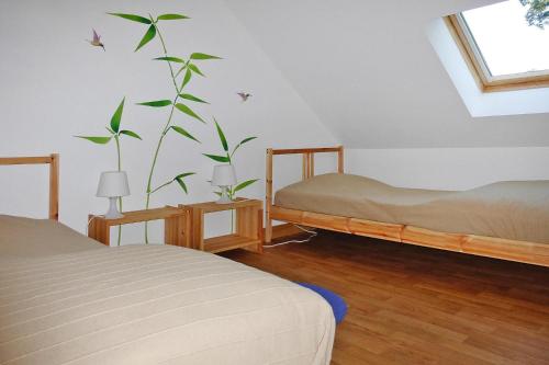 ein Schlafzimmer mit 2 Betten und einer Pflanze an der Wand in der Unterkunft Apartment, Manneville-es-Plains in Manneville-ès-Plains