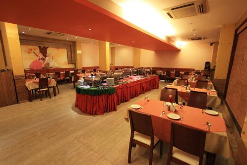 a dining room with tables and chairs in a restaurant at Parijatha Gateway in Bengaluru