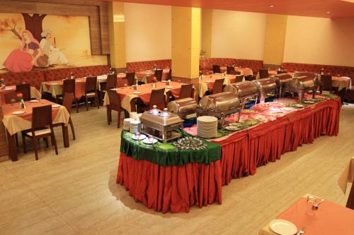 a dining room with tables and chairs and tablesktop at Parijatha Gateway in Bengaluru