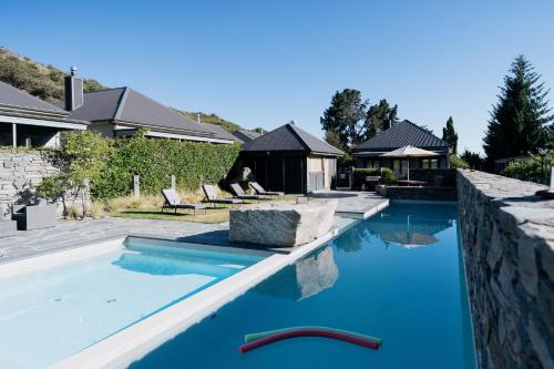 a swimming pool with blue water in a house at Cardrona Valley Escape - Cardrona Holiday Home in Cardrona