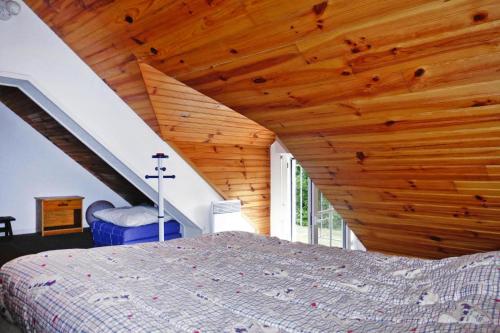 une chambre avec un lit et un plafond en bois dans l'établissement Chalet near Mont St Michel & Nature Trails, à Céaux