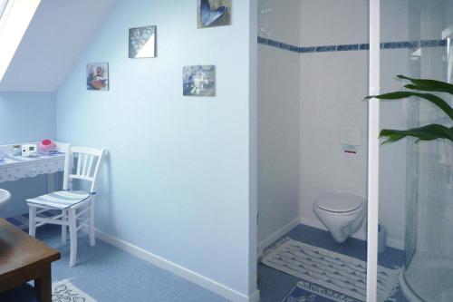 La salle de bains est pourvue de toilettes et de photos murales. dans l'établissement Holiday Home near Mont St Michel Beach, à Coudeville-sur-Mer