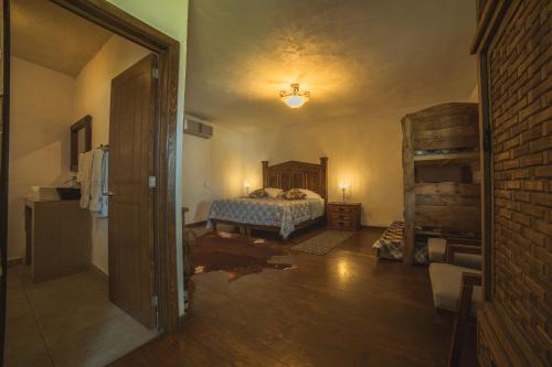 a bedroom with a bed and a brick wall at Hotel Posada las Nubes in Parras de la Fuente