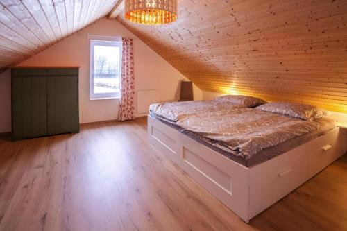 una camera da letto con un grande letto in mansarda di Holiday home Partwitz, Elsterheide a Elsterheide
