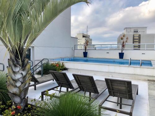 - un balcon avec des chaises et une piscine dans un bâtiment dans l'établissement SeuLar o conforto de um Lar em Qualquer Lugar, à São Paulo