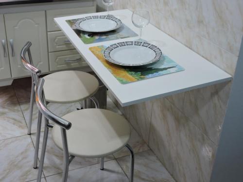 a table with two chairs and two plates on it at 10 Studios in Sao Paulo