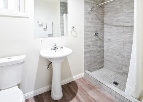 Un baño blanco con lavabo y ducha. en Holly Park Motel near LAX, en Inglewood
