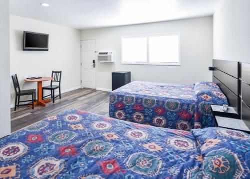 a hotel room with two beds and a table at Holly Park Motel near LAX in Inglewood