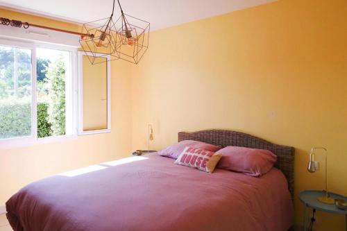 ein Schlafzimmer mit einem Bett mit rosa Kissen darauf in der Unterkunft Cottage, Saint Germain sur Ay in Saint-Germain-sur-Ay