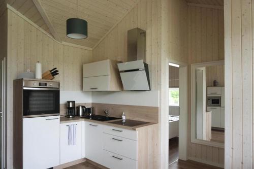 a kitchen with white cabinets and a counter top at Ferienhaus Nordlys mit Sauna am Dümmer See, Dümmer in Dümmer