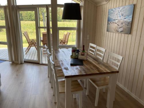 a dining room with a wooden table and chairs at Ferienhaus Larsson mit Sauna am Dümmer See, Dümmer in Dümmer