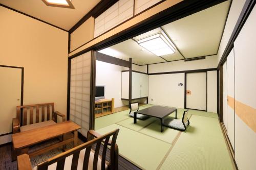 a living room with a table and a bench at Matsunoi in Minakami