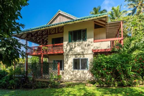 a house with a balcony and a yard at Muri Retreat Apartments in Rarotonga