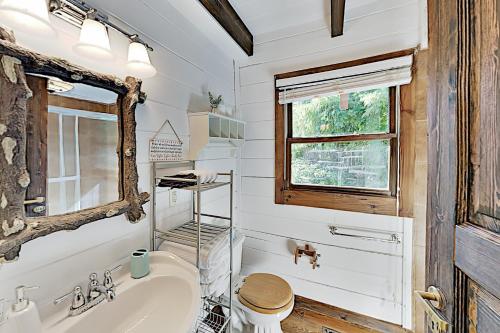 baño con lavabo y aseo y ventana en Crestwood Retreat, en Arden