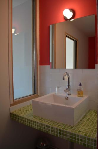 une salle de bain avec un lavabo blanc et un miroir dans l'établissement Le Jardin Secret, à Gauriac