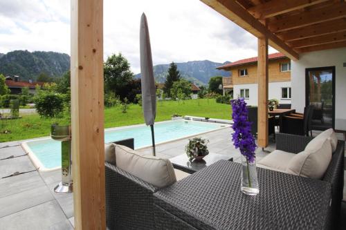 a patio with a table and chairs and a pool at Chalet Chiemgau, Inzell in Inzell