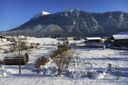 a snow covered village with a mountain in the background at Chalet Chiemgau, Inzell in Inzell
