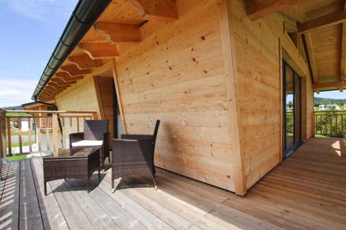a wooden cabin with chairs and a table on a deck at Chalet Chiemgau, Inzell in Inzell
