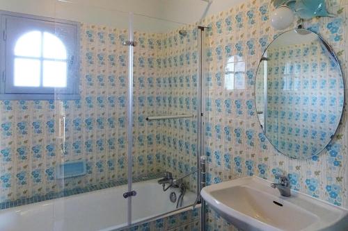 a bathroom with a shower and a sink and a mirror at Holiday home with sea views, Trebeurden in Trébeurden