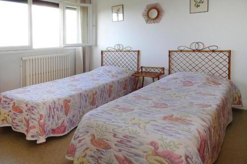 two beds sitting next to each other in a bedroom at Holiday home with sea views, Trebeurden in Trébeurden