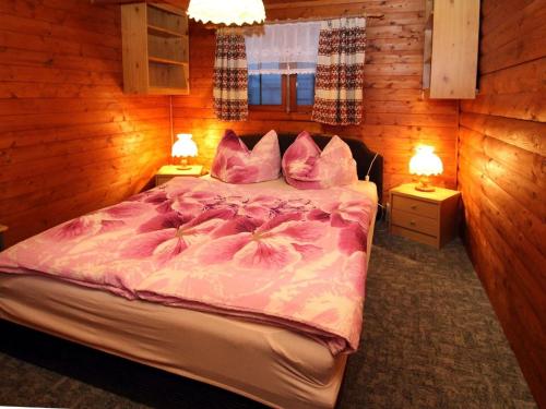 a bedroom with a bed with pink sheets and pillows at Blockhouse Spreewald, Alt Zauche in Alt Zauche