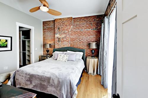 a bedroom with a brick wall and a bed at The Lofts at Church St in Asheville