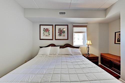 een witte slaapkamer met een groot bed. bij Water Street Condos III in Wilmington
