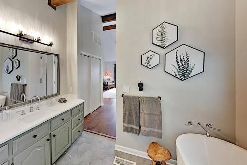a bathroom with a tub and a sink and a mirror at Young's Mountain Hideaway in Lake Lure