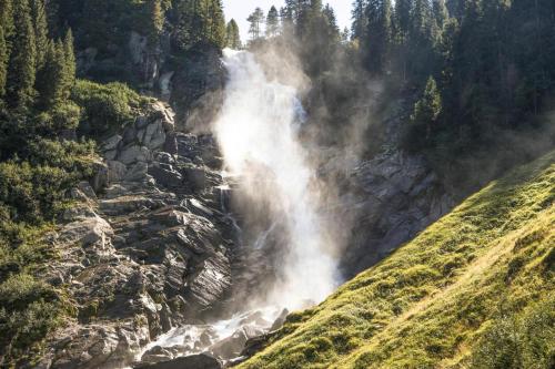 a waterfall in the middle of a mountain with trees at House in Krimml near Waterfalls & Hiking Trails in Krimml