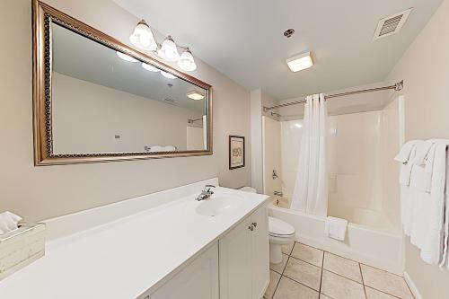 y baño con lavabo, aseo y espejo. en River View Condo A, en Wilmington