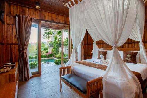 a bedroom with a bed with a canopy at Yanyan Resort Ubud in Ubud