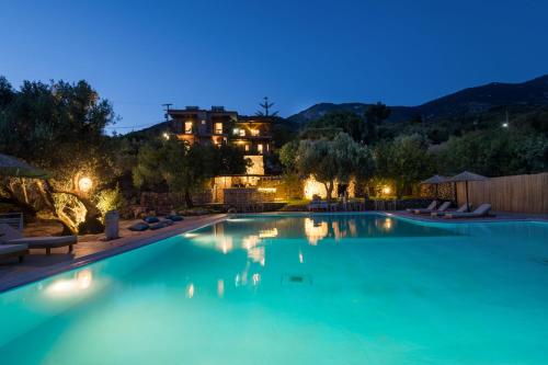 a swimming pool at night with a house in the background at Hilltop Kefalonia in Argostoli